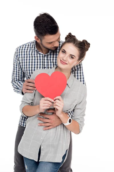 Freund umarmt Freundin mit Papierherz auf weißem Valentinstag-Konzept — Stockfoto