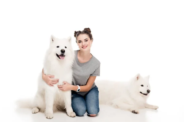 Fille souriante assise avec des chiens sur blanc — Photo de stock