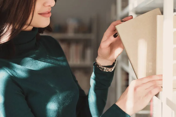 Immagine ritagliata di studente che prende libro dagli scaffali in biblioteca — Foto stock