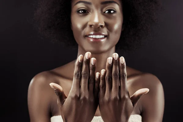 Beautiful african american woman showing her nails isolated on black — Stock Photo