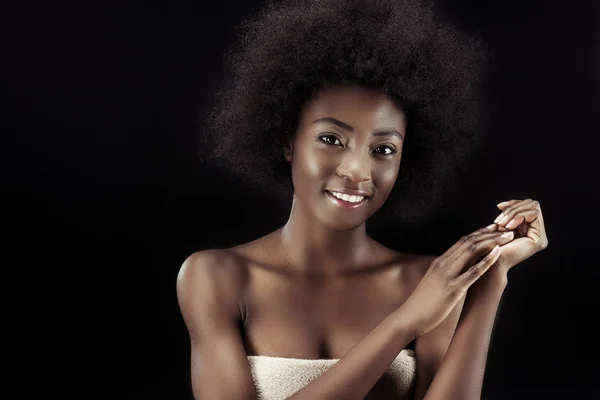 Привлекательная африканская американка, покрытая полотенцем, изолированным на черном — стоковое фото