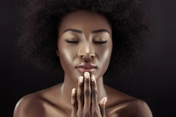Hermosa mujer afroamericana con los ojos cerrados aislados en negro - foto de stock