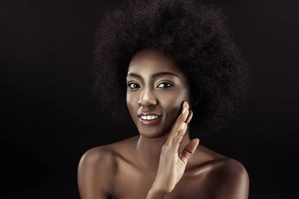 Hermosa africana americana tocando su cara aislado en negro - foto de stock