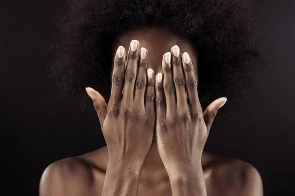Афроамериканська жінка вкриває обличчя руками ізольовано на чорному — стокове фото