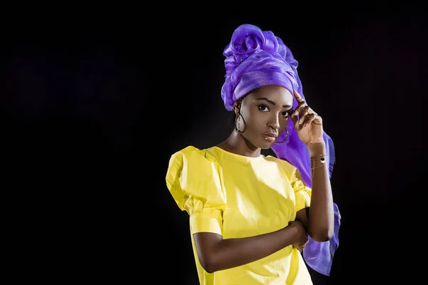 Attractive african american woman in purple wire head wrap clothing isolated on black — Stock Photo