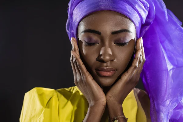 Крупный план молодой африканской женщины в стильной проволочной головке, изолированной на черном — стоковое фото