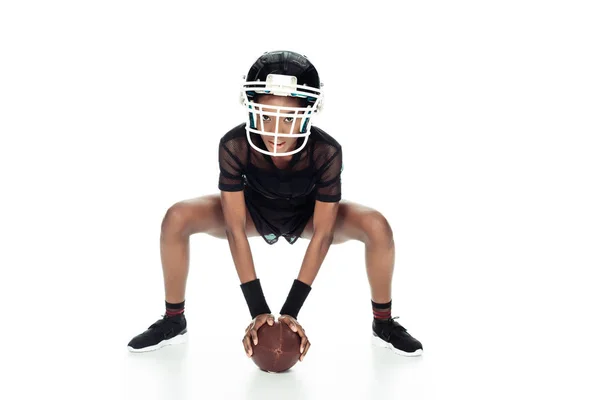 Jugador de fútbol americano femenino con pelota de pie en posición de inicio aislado en blanco - foto de stock