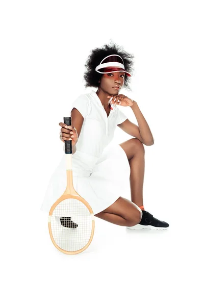 Joueuse de tennis sérieuse avec raquette assise sur le sol isolé sur blanc — Photo de stock