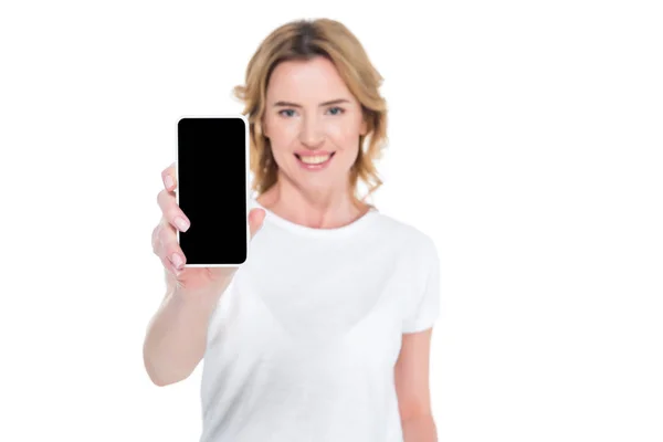 Ritratto di donna sorridente che mostra smartphone con schermo bianco isolato su bianco — Stock Photo