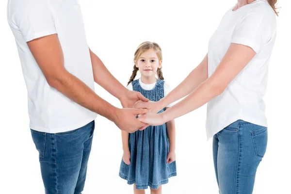 Батьки тримають руки, поки дочка стоїть поруч, ізольовані на білому — стокове фото