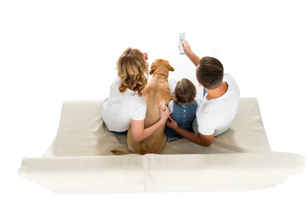 Vista aérea de la familia con perro viendo la televisión en el sofá, aislado en blanco - foto de stock