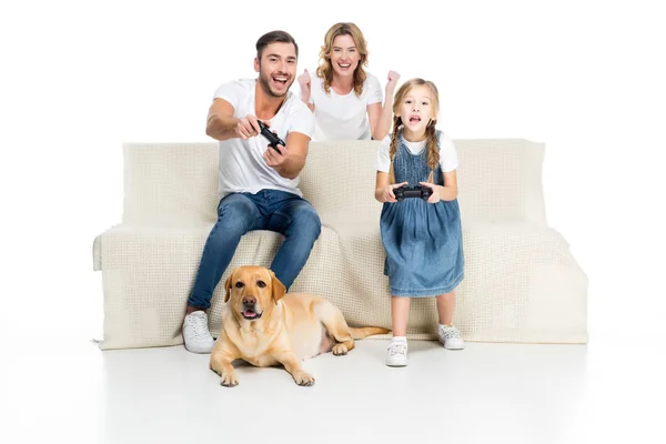 Aufgeregte Familie spielt Videospiel mit Steuerknüppeln, während Hund in der Nähe sitzt, isoliert auf weiß — Stockfoto