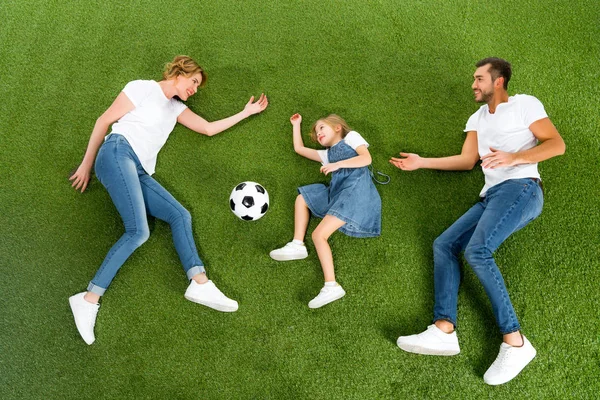 Blick von oben auf Familie beim gemeinsamen Fußballspielen auf grünem Rasen — Stockfoto
