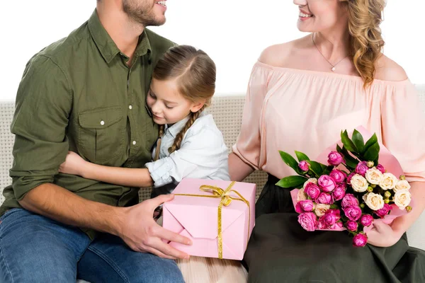 Vista parcial de familia feliz con regalos en sofá aislado en blanco - foto de stock
