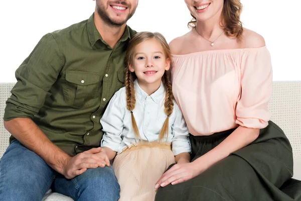 Recortado tiro de feliz hija y padres descansando en sofá juntos aislado en blanco - foto de stock