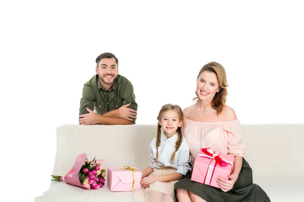 Família feliz com presentes no sofá isolado no branco — Fotografia de Stock