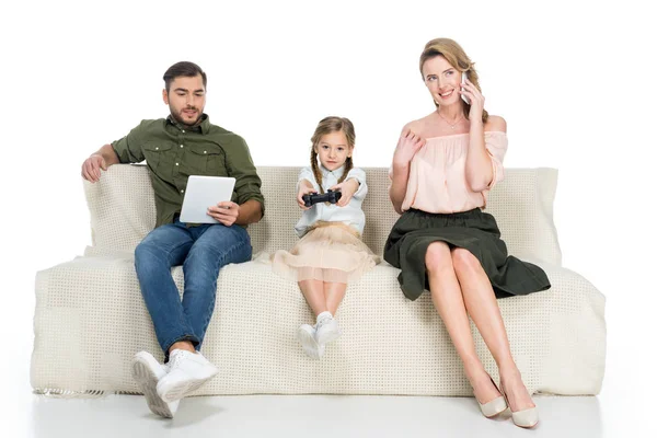 Eltern und Tochter mit verschiedenen digitalen Geräten auf Sofa isoliert auf weiß — Stockfoto
