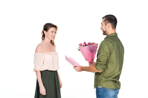 Vista lateral do homem apresentando buquê de flores e cartão postal para a esposa isolado em branco — Fotografia de Stock