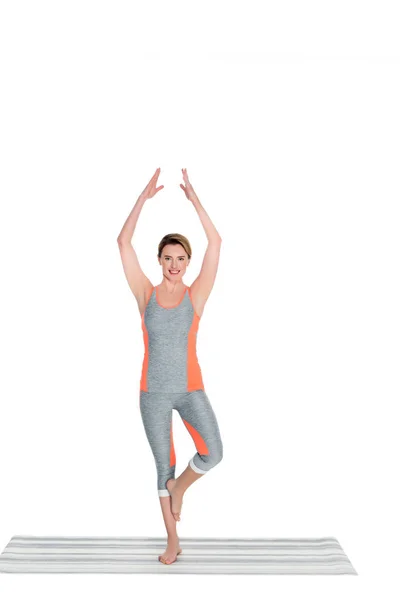 Woman in sportswear practicing yoga tree pose isolated on white — Stock Photo