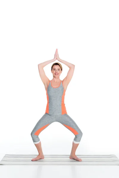 Женщина в спортивной одежде практикующая йогу изолированная на белом — стоковое фото