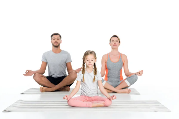 Família atlética praticando ioga em tapetes juntos isolados em branco — Fotografia de Stock