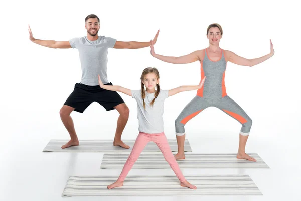 Sportliche Familie praktiziert Yoga auf Matten zusammen isoliert auf weiß — Stockfoto