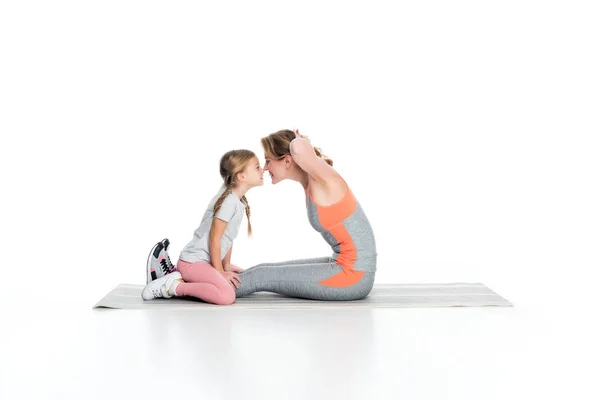 Sportive mère et fille exerçant ensemble isolé sur blanc — Photo de stock