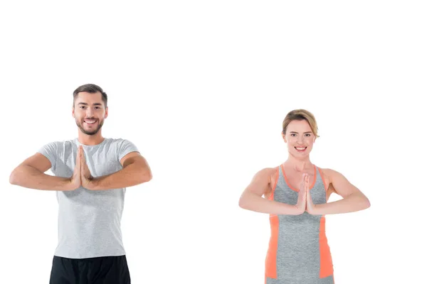 Coppia sorridente in abbigliamento sportivo praticare yoga isolato su bianco — Foto stock