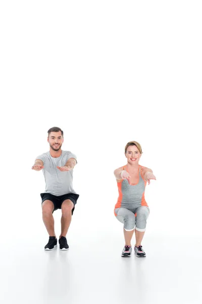 Sportliches Paar in Sportkleidung macht Sit-Ups isoliert auf Weiß — Stockfoto