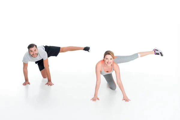 Pareja deportiva haciendo ejercicio juntos aislados en blanco - foto de stock