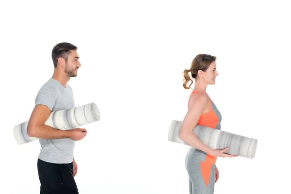 Vue latérale du couple athlétique avec tapis de yoga isolés sur blanc — Photo de stock