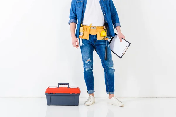 Immagine ritagliata del lavoratore in piedi con appunti vicino alla scatola degli strumenti — Foto stock