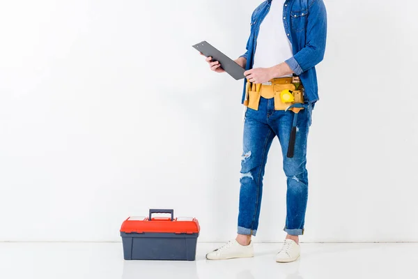 Обрезанное изображение работника, стоящего с буфером возле ящика с инструментами — стоковое фото