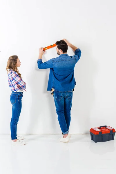 Vista posteriore del fidanzato misurazione planarità parete — Foto stock