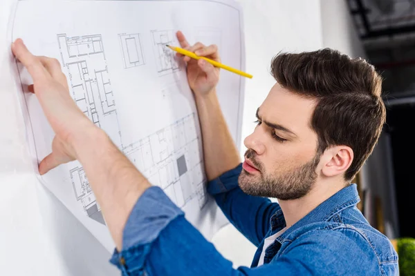 Guapo arquitecto escribiendo sobre plano en blanco - foto de stock