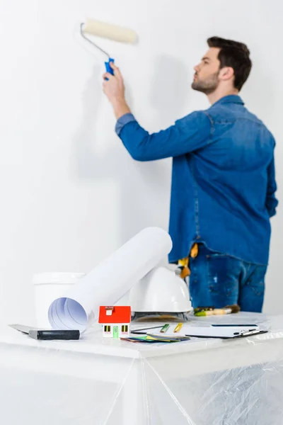 Mur de peinture homme avec pinceau rouleau de peinture — Photo de stock