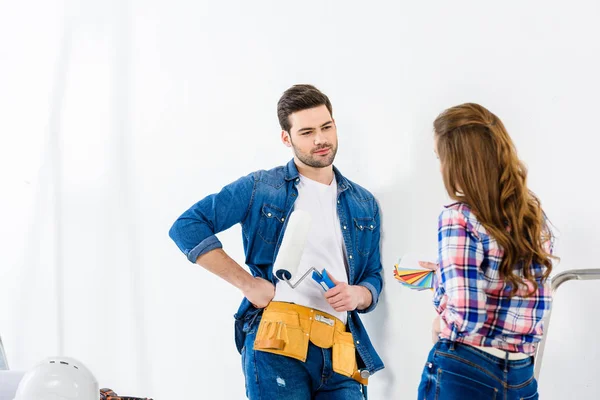 Smiling couple talking at looking at each other during making repairs — Stock Photo