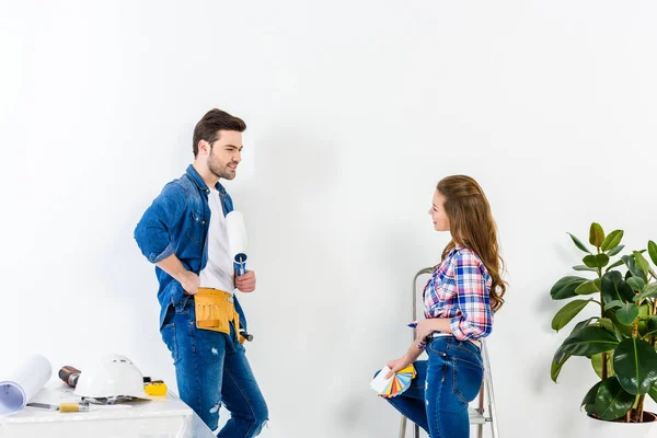 Smiling couple talking at looking at each other during making repairs — Stock Photo