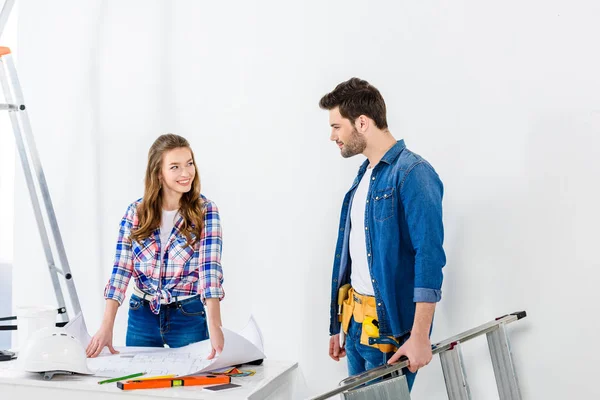 Lächelndes Paar, das sich beim Reparieren zu Hause anschaut — Stockfoto