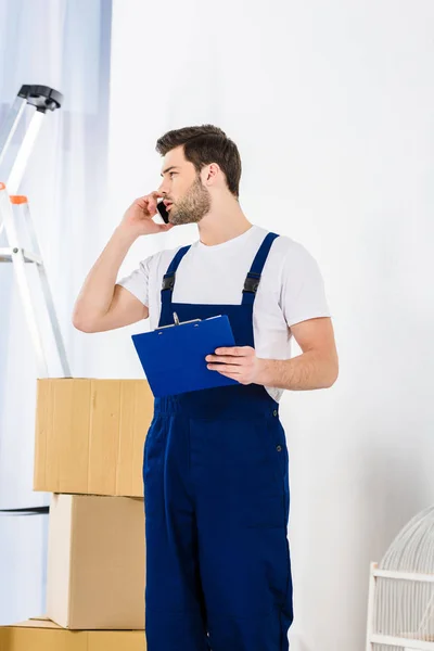 Hombre hablando por teléfono inteligente y mirando hacia otro lado - foto de stock