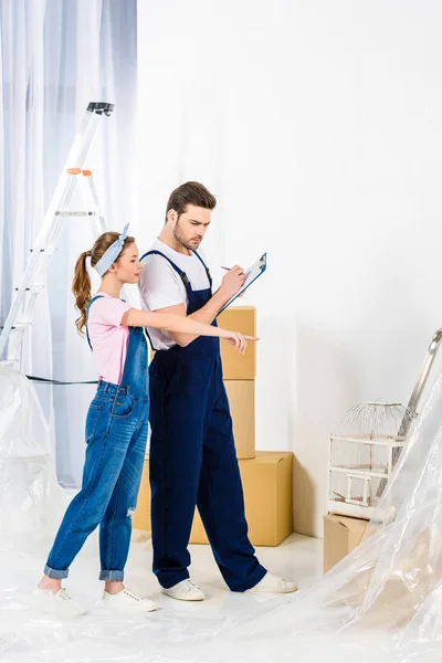 Chica señalando algo a trabajador de servicios de reubicación - foto de stock