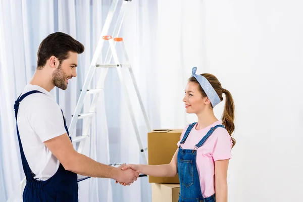 Girl and relocation service worker shaking hands — Stock Photo