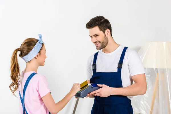 Girl paying to relocation service worker with credit card for moving boxes — Stock Photo