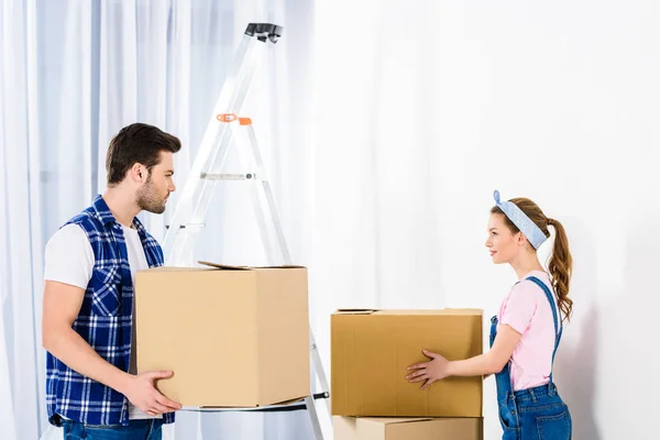 Fidanzato e fidanzata scatole in movimento e guardando l'un l'altro — Foto stock