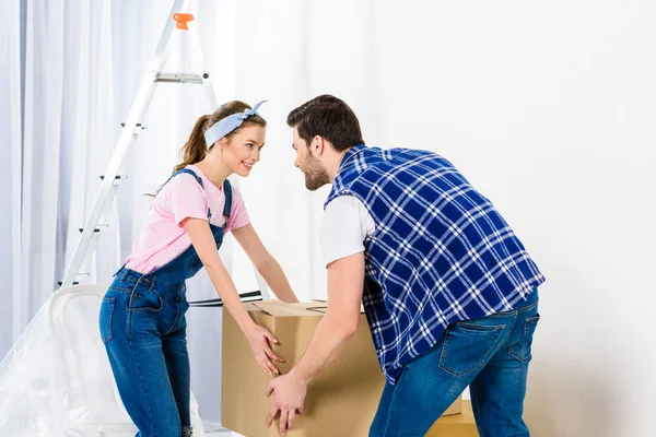 Boyfriend and girlfriend taking box and looking at each other — Stock Photo