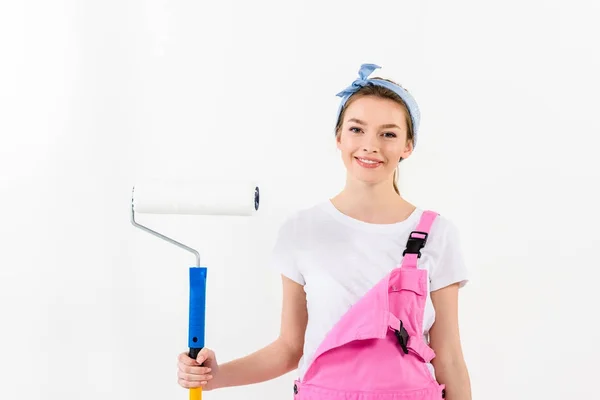 Fille souriante debout avec pinceau à rouleaux de peinture — Photo de stock