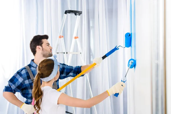 Fidanzato e fidanzata pittura muro con vernice blu — Foto stock