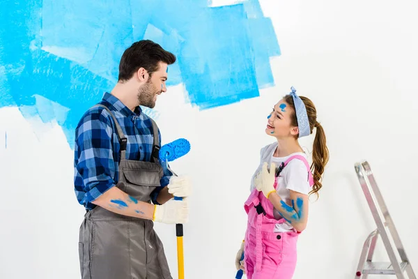 Smiling boyfriend and girlfriend looking at each other and making repairs — Stock Photo