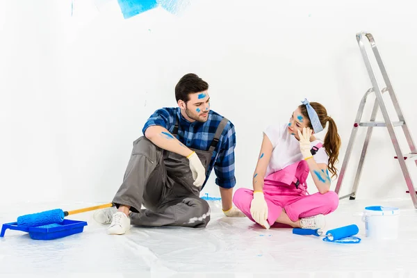 Хлопець і дівчина сидять на підлозі в кімнаті з ремонтом — стокове фото