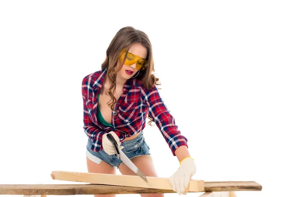 Sexy girl in goggles working with saw, isolated on white — Stock Photo